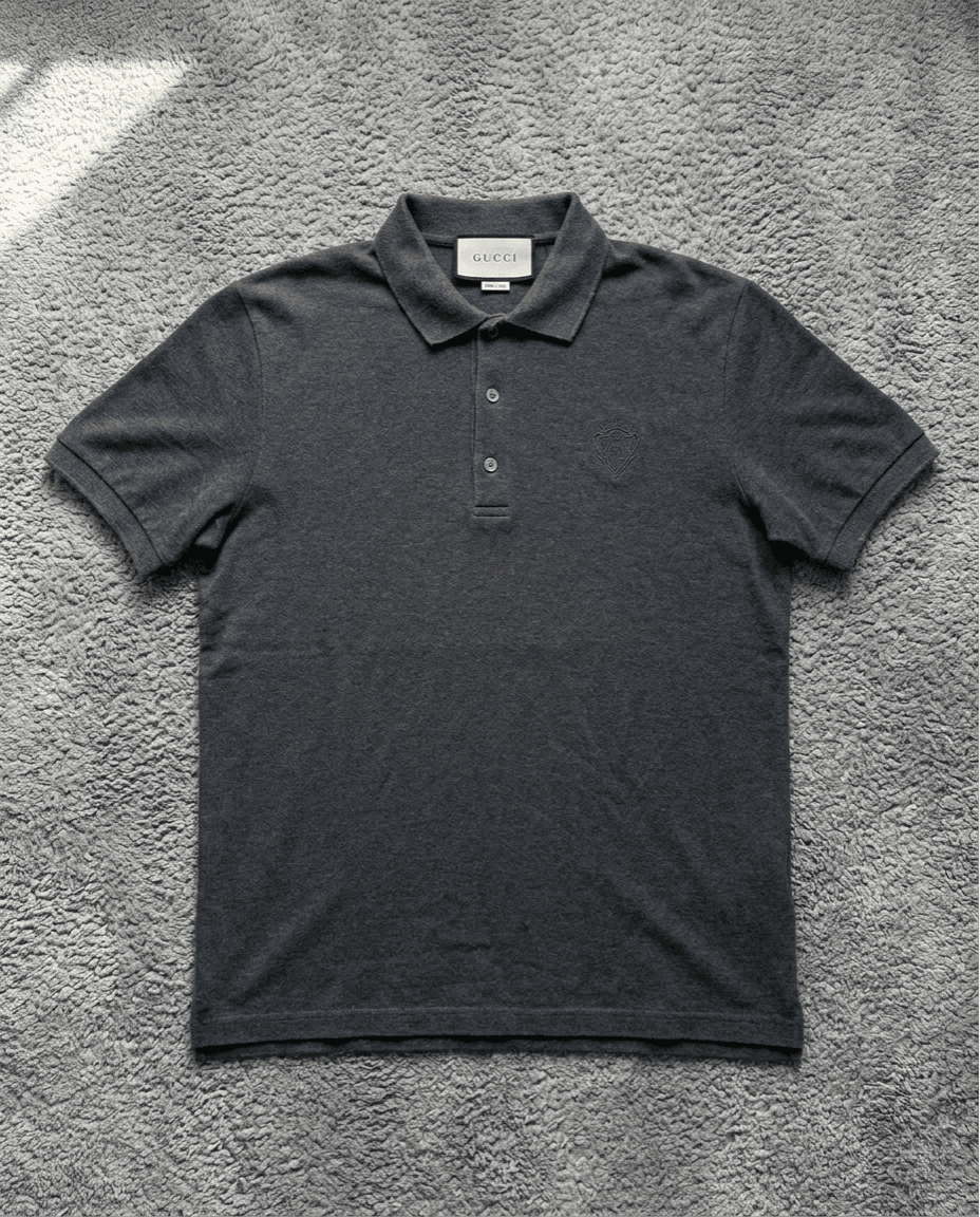 Polo Gucci gris foncé sur tapis gris
